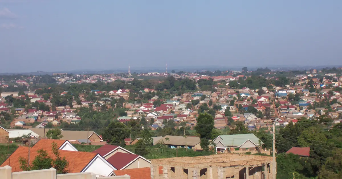 Rencontre à Kampala : les toits et les collines de la ville vus depuis une hauteur, sous un ciel bleu