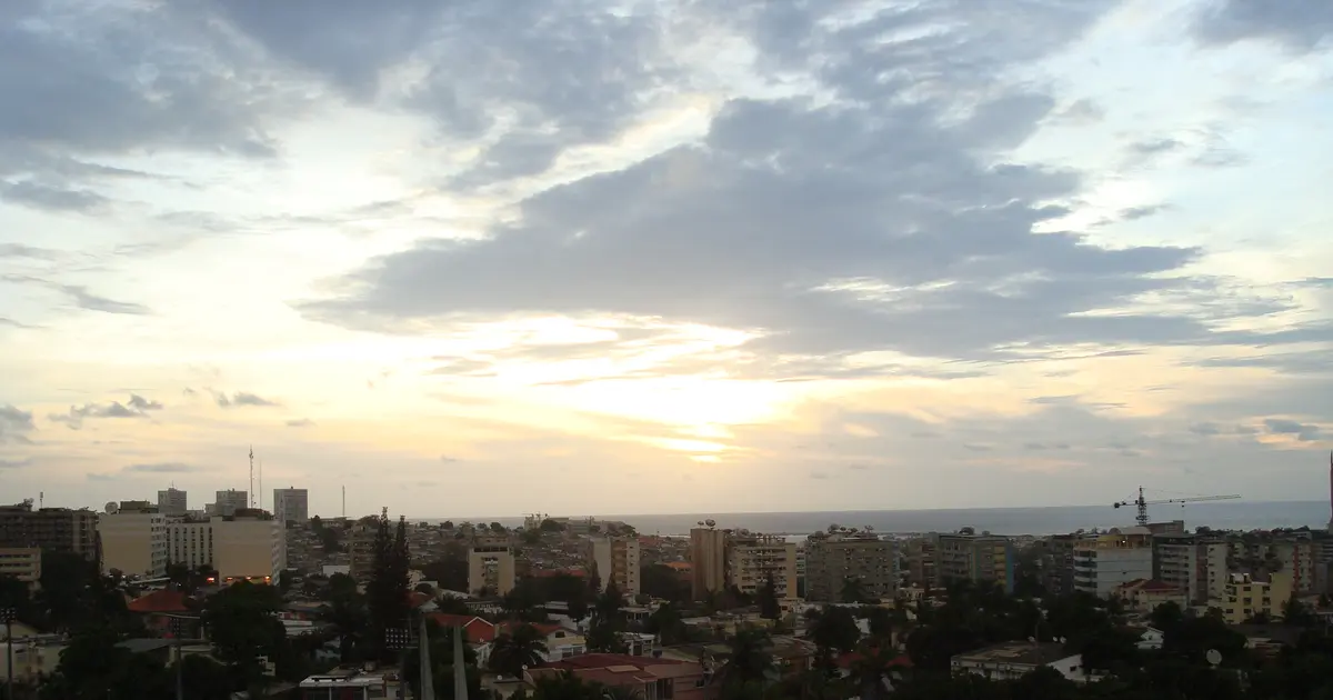 Rencontre à Luanda : la ville au coucher du soleil, vue depuis la ville haute, avec l'océan à l'horizon